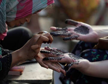 Pakistan Beautician paints customers hands for Eid al-Fitr