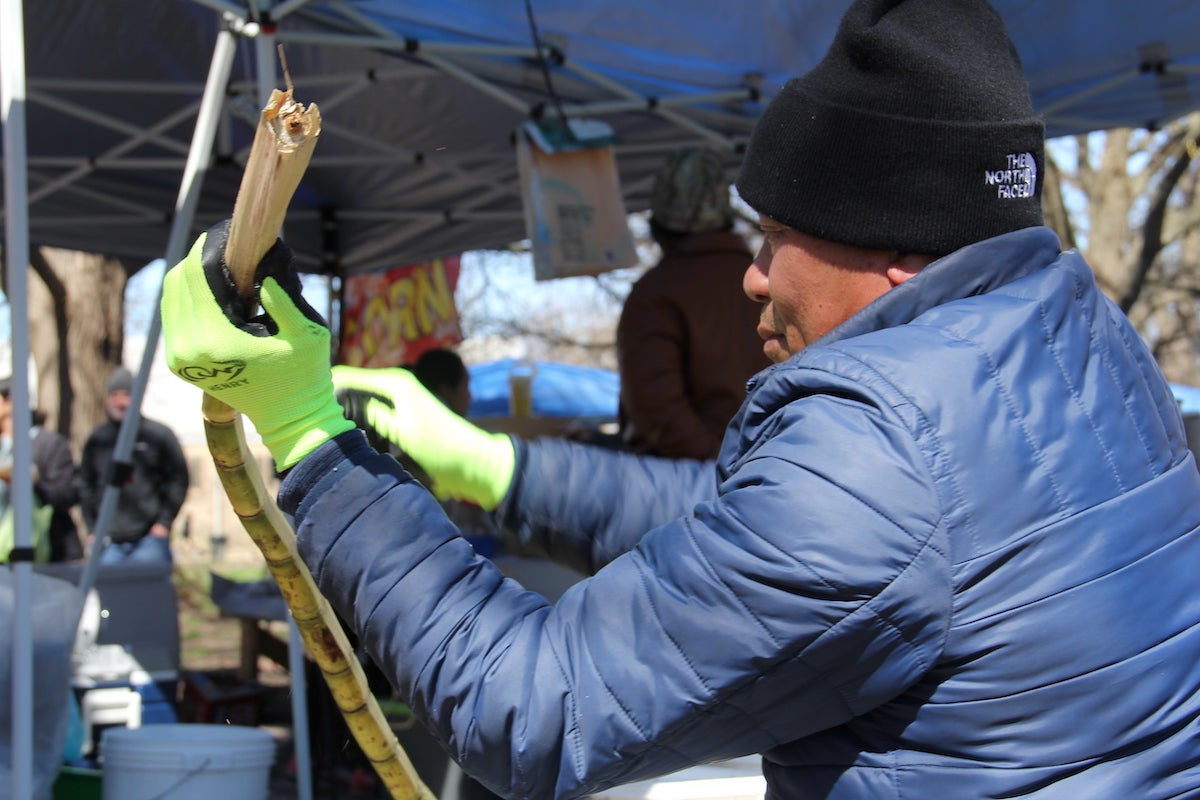 Sarann Oung chops up some fresh sugar cane at the Southeast Asian Market