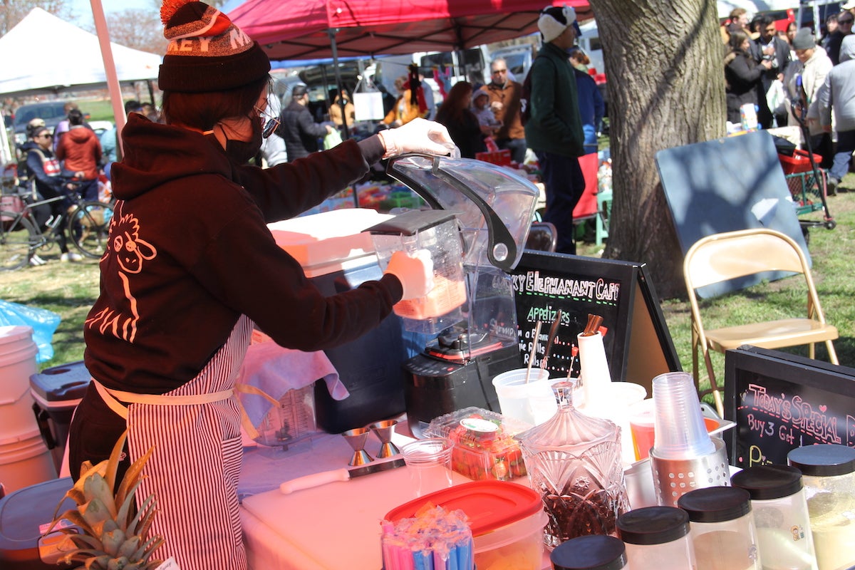 A vendor works a juice blender at the Southeast Asian Market in Philadelphia