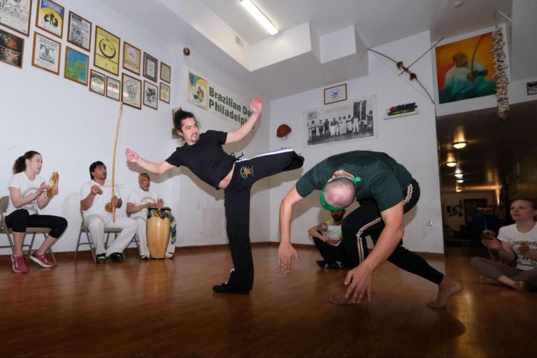 Ricardo Melendez (right) and Peter DiGeronimo, members of Project Capoeira, throw kicks in the circle, also known as the “roda”.)