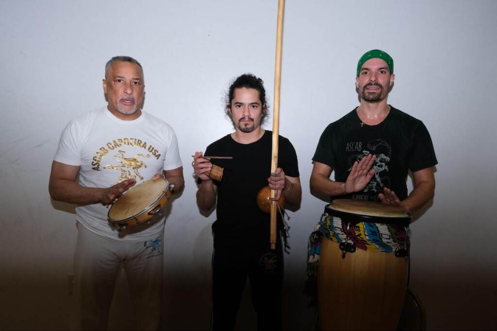 The capoeira musicians. Adenilson Dos Santos, Mestre Doutor (left), holds the pandeiro, Ricardo Melendez (center ) holds the birimbao, and Peter DiGeronimo (right) plays the atabaque. 