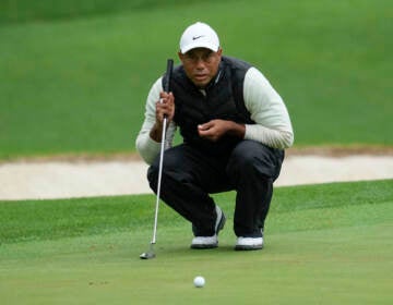 Tiger Woods lines up a putt on the 16th hole during the weather-delayed second round of the Masters golf tournament