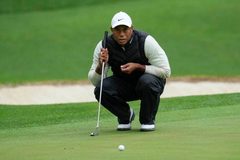 Tiger Woods lines up a putt on the 16th hole during the weather-delayed second round of the Masters golf tournament