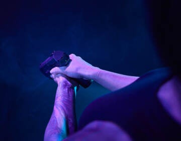 A person holds a gun in front of htem.