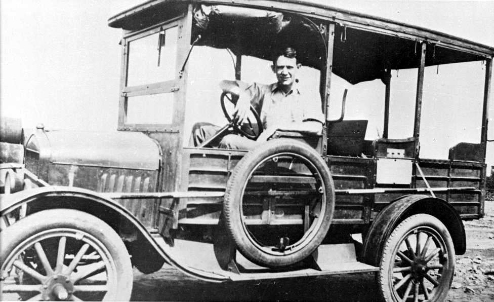 Samuel Baxter poses for a photo inside of a car in a black-and-white photo.