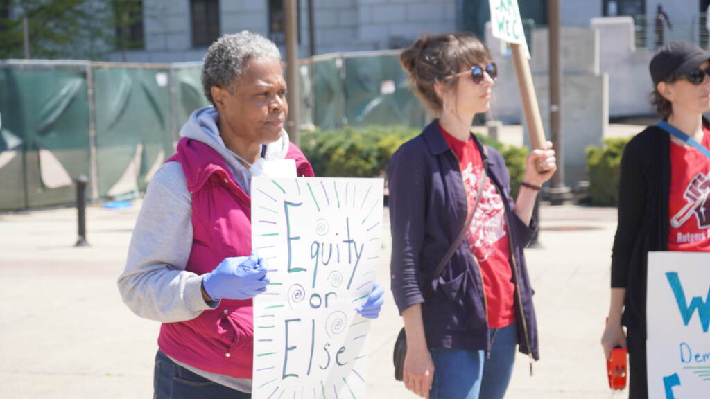 A woman holding a sign at a protest.