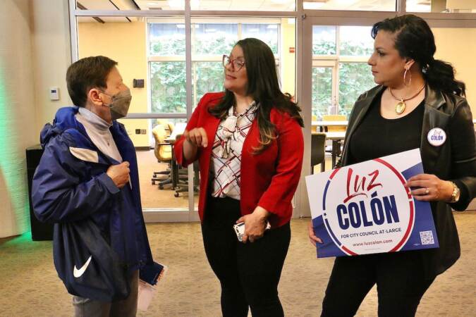 Philadelphia City Council candidate Luz Colon (center) talks with voters at a candidate convention hosted by WHYY. (Emma Lee/WHYY)