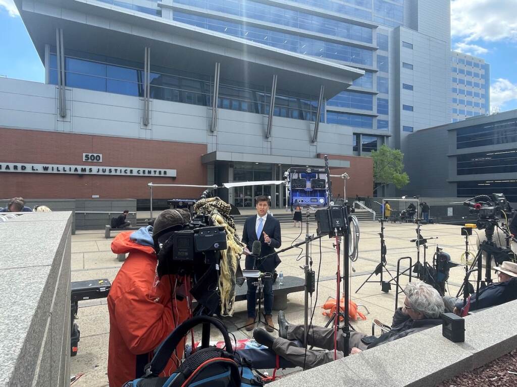 A reporter stands outside of a Wilmington courthouse.