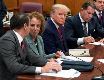 Former President Donald Trump sits at the defense table with his defense team in a Manhattan court