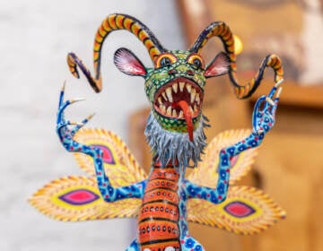 A close-up of a painted paper maché fantastical creature.