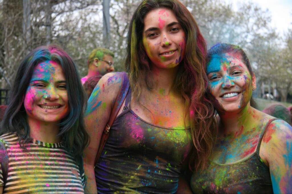 People pose for a photo covered in brightly-colored dyes.