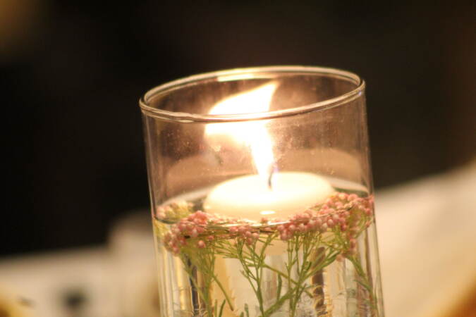 A close-up of a lit, decorated candle.