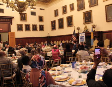 A room full of people seated at tables.