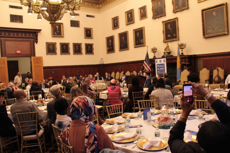 A room full of people seated at tables.