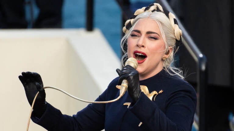 Lady Gaga sings into a microphone.