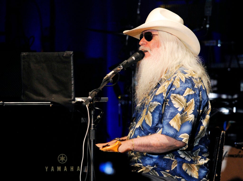 Leon Russell plays the piano and sings in a concert performance.