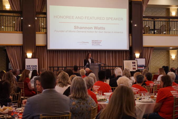 Shannon Watts speaking at a podium.