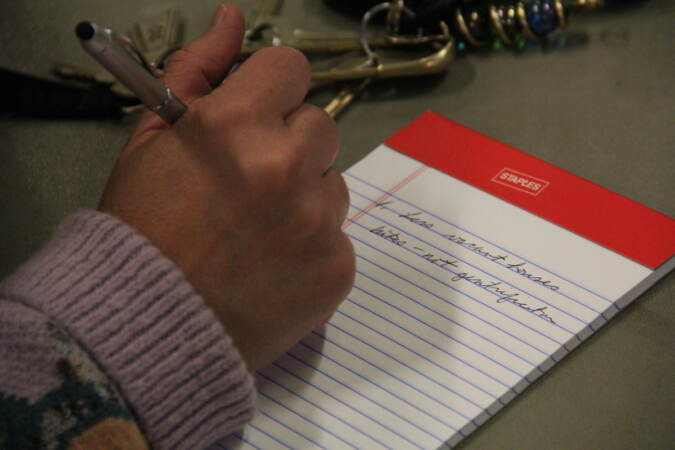 A person writes on a legal pad.
