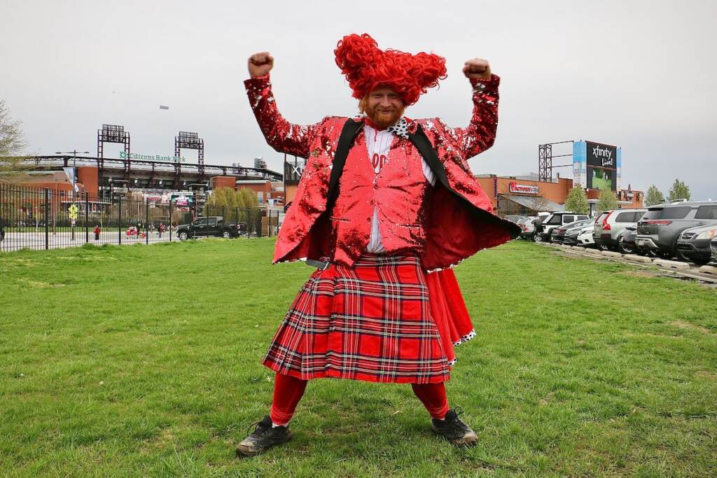 Mike Rahn, decked out all in red, poses outside of Citizens Bank Park.