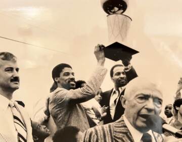 Members of the Philadelphia 76ers raise the NBA championship trophy in 1983,