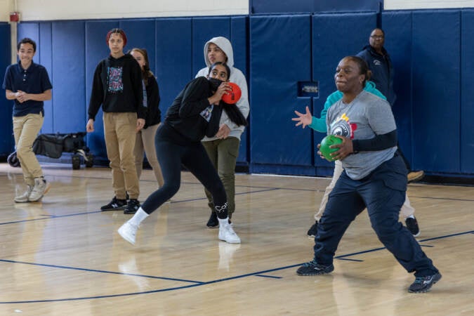 7th and 8th graders from Mastery Melina Upper School play dodge ball with Camden County police officers at the 10th anniversary event for the Camden County Police Department on May 1, 2023. (Kimberly Paynter/WHYY)