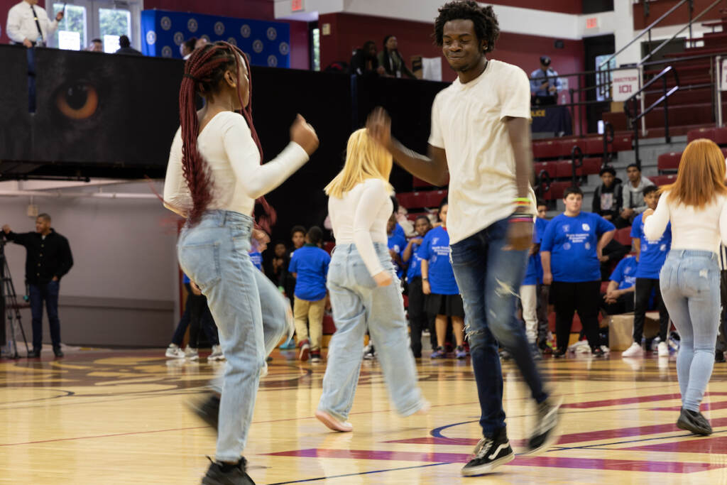 Jordan Smith, right, performs with his dance team in a gym.