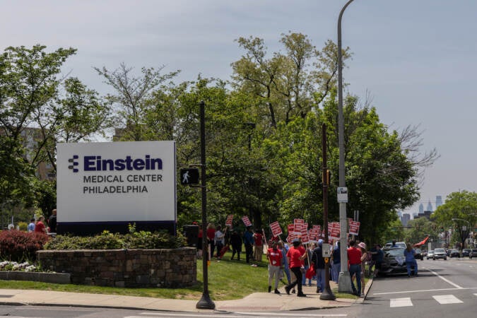 Nurses march in front of a sign that reads Einstein Medical Center Philadelphia.