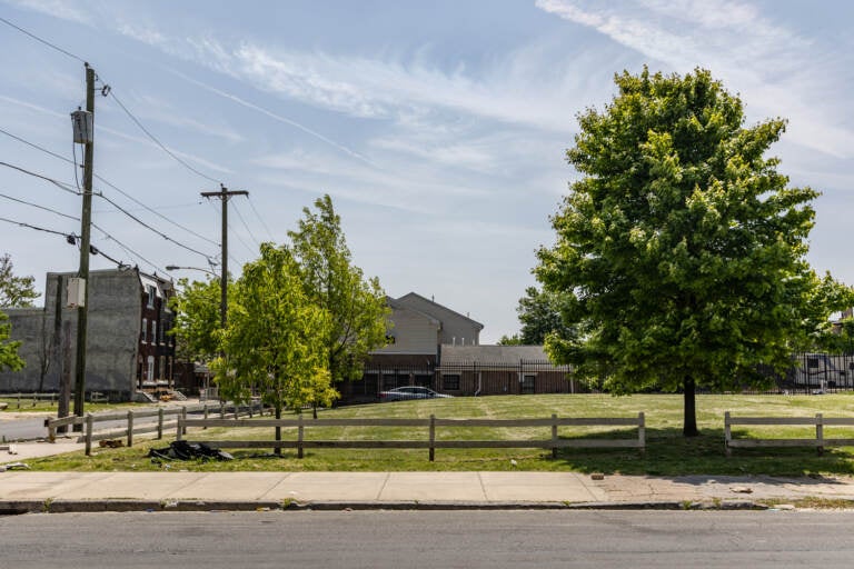 A vacant lot is visible on a sunny day.