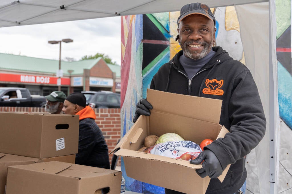 Keith Pate holding a box of produce at the block party.