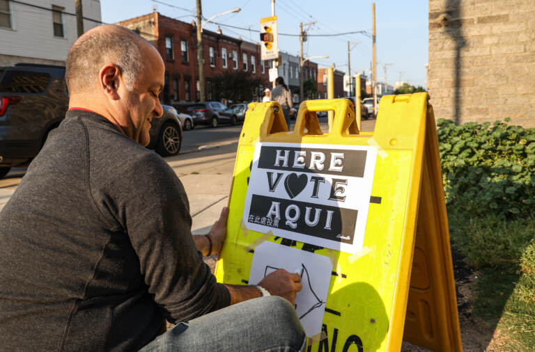 Jai Agrawal posts a sign outside a polling station in Philadelphia