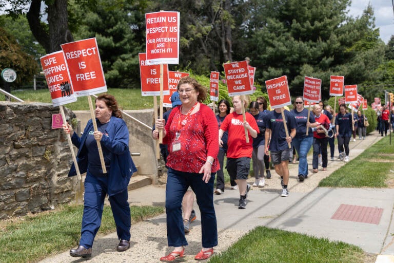 Protesters march on a sidewalk.