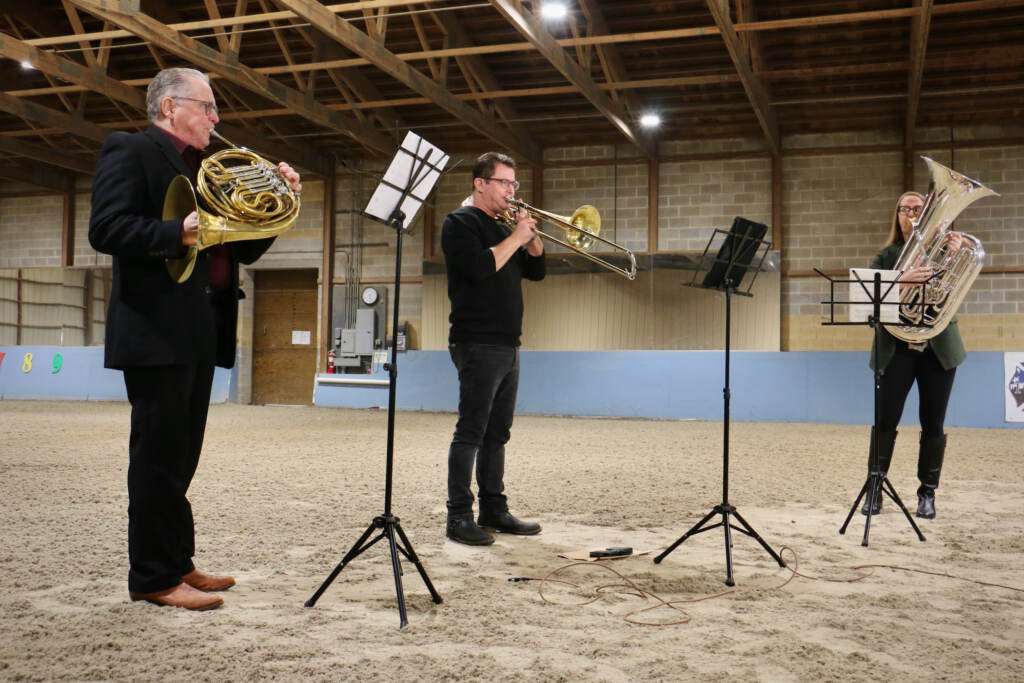 Philadelphia Orchestra musicians (from left) Jeffrey Lang, Nitzan Haroz, and Carol Jantsch play in the middle of a stable building.