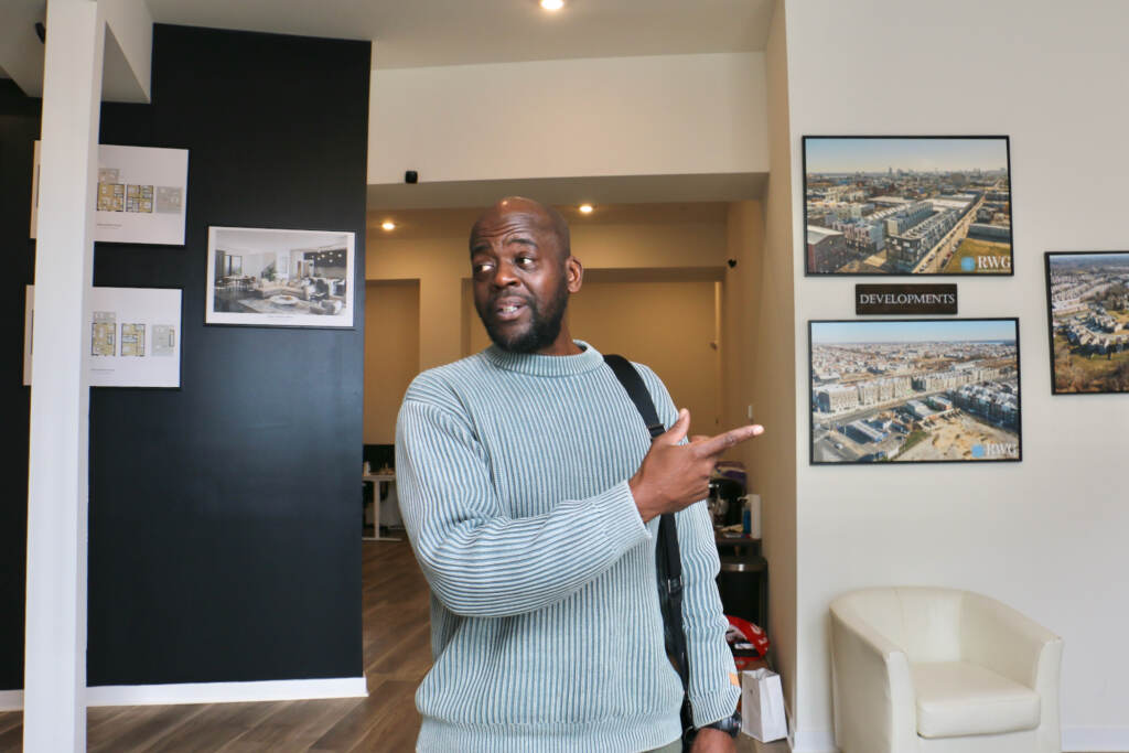 Dawud Bey points towards something in his office.