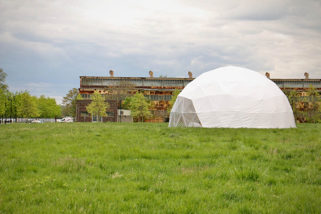 A dome is visible in a green field.