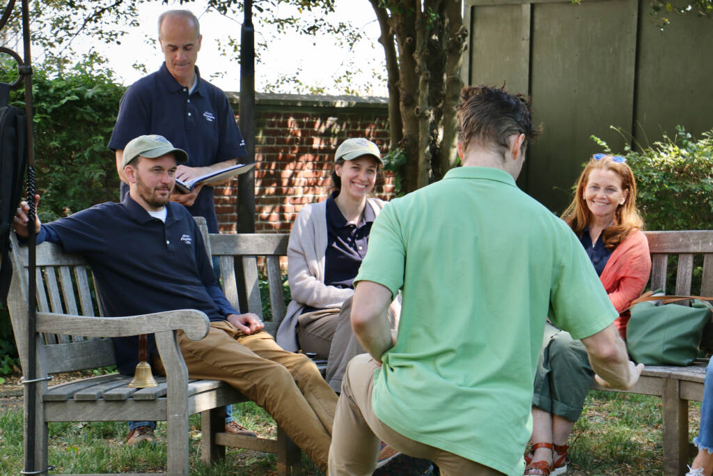 People on benches watch a performer.