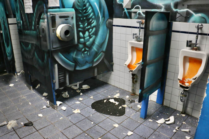 Smashed urinals are visible.