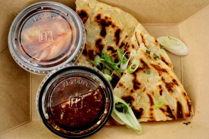 An overhead view of scallion pancakes with kimchi.