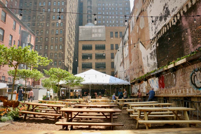 A number of picnic tables and a large tent are visible in an open lot.