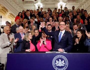 Pa. Gov. Josh Shapiro holds up Senate President Pro Tempore Kim Ward's hand as he signs the first bill of his tenure.
(