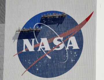 Workers near the top of the 526 ft. Vehicle Assembly Building at the Kennedy Space Center spruce up the NASA logo standing on scaffolds in Cape Canaveral, Fla., Wednesday, May 20, 2020. A SpaceX Falcon 9 rocket scheduled for May 27 will launch a Crew Dragon spacecraft on its first test flight with astronauts on-board to the International Space Station. (AP Photo/John Raoux)