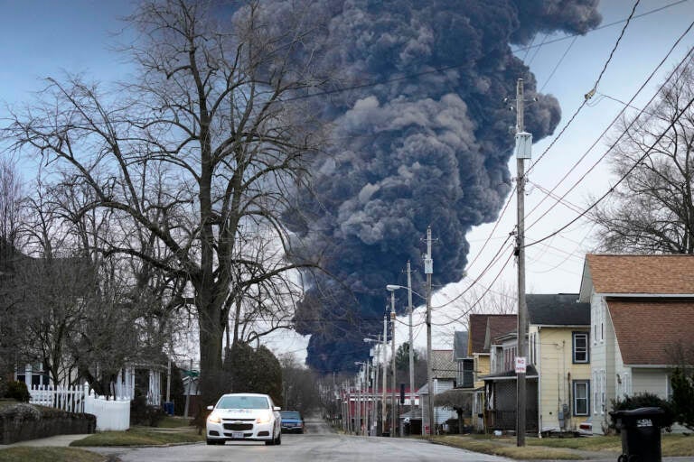 A black plume rises over East Palestine, Ohio, as a result of a controlled detonation of a portion of the derailed Norfolk Southern trains.