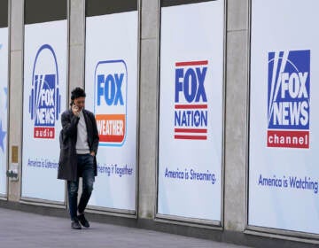 A man walks past the News Corp. and Fox News headquarters on Wednesday, April 19, 2023, in New York. Fox Corp.'s hefty $787.5 million settlement with Dominion over defamation charges is unlikely to make a dent in Fox's operations, analysts say. (AP Photo/Mary Altaffer, File)
