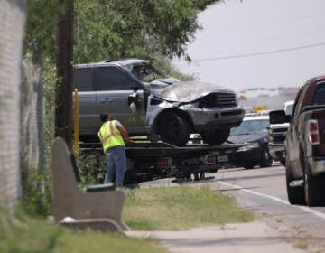 Emergency personnel take away a damaged vehicle after a fatal collision in Brownsville, Texas, on Sunday, May 7, 2023. Several migrants were killed after they were struck by a vehicle while waiting at a bus stop near Ozanam Center, a migrant and homeless shelter.