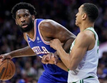 Philadelphia 76ers' Joel Embiid (left) tries to get past Boston Celtics' Malcolm Brogdon during the first half of Game 4 in an NBA basketball Eastern Conference semifinals playoff series, Sunday, May 7, 2023, in Philadelphia