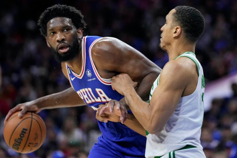 Philadelphia 76ers' Joel Embiid (left) tries to get past Boston Celtics' Malcolm Brogdon during the first half of Game 4 in an NBA basketball Eastern Conference semifinals playoff series, Sunday, May 7, 2023, in Philadelphia