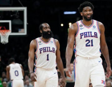 Philadelphia 76ers center Joel Embiid (21) smiles while walking down court with James Harden (1) during the second half of Game 5 in the NBA basketball Eastern Conference semifinals playoff series against the Boston Celtics