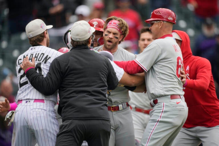 Philadelphia Phillies designated hitter Bryce Harper, back center, is held back from pursuing Colorado Rockies relief pitcher Jake Bird by, from front left, Colorado's Ryan McMahon, first base umpire Ben May and Philadelphia third base coach Dusty Wathan in the seventh inning of a baseball game, Sunday, May 14, 2023, in Denver. 
(AP Photo/David Zalubowski)