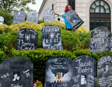 Jayde Newton helps to set up cardboard gravestones with the names of victims of opioid abuse outside the courthouse where the Purdue Pharma bankruptcy is taking place in White Plains, N.Y., on Aug. 9, 2021. A three-judge panel of the 2nd U.S. Circuit Court of Appeals in New York on Tuesday, May 30 overturned a lower court’s 2021 ruling that found bankruptcy courts did not have the authority to protect members of the Sackler family who own the company and who have not filed for bankruptcy protection from lawsuits