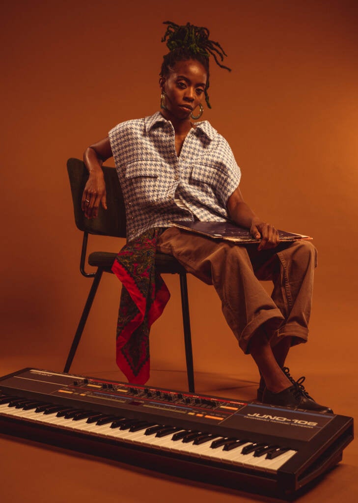 A musician sits next to a keyboard.