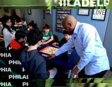 Man teaching children how to play scrabble